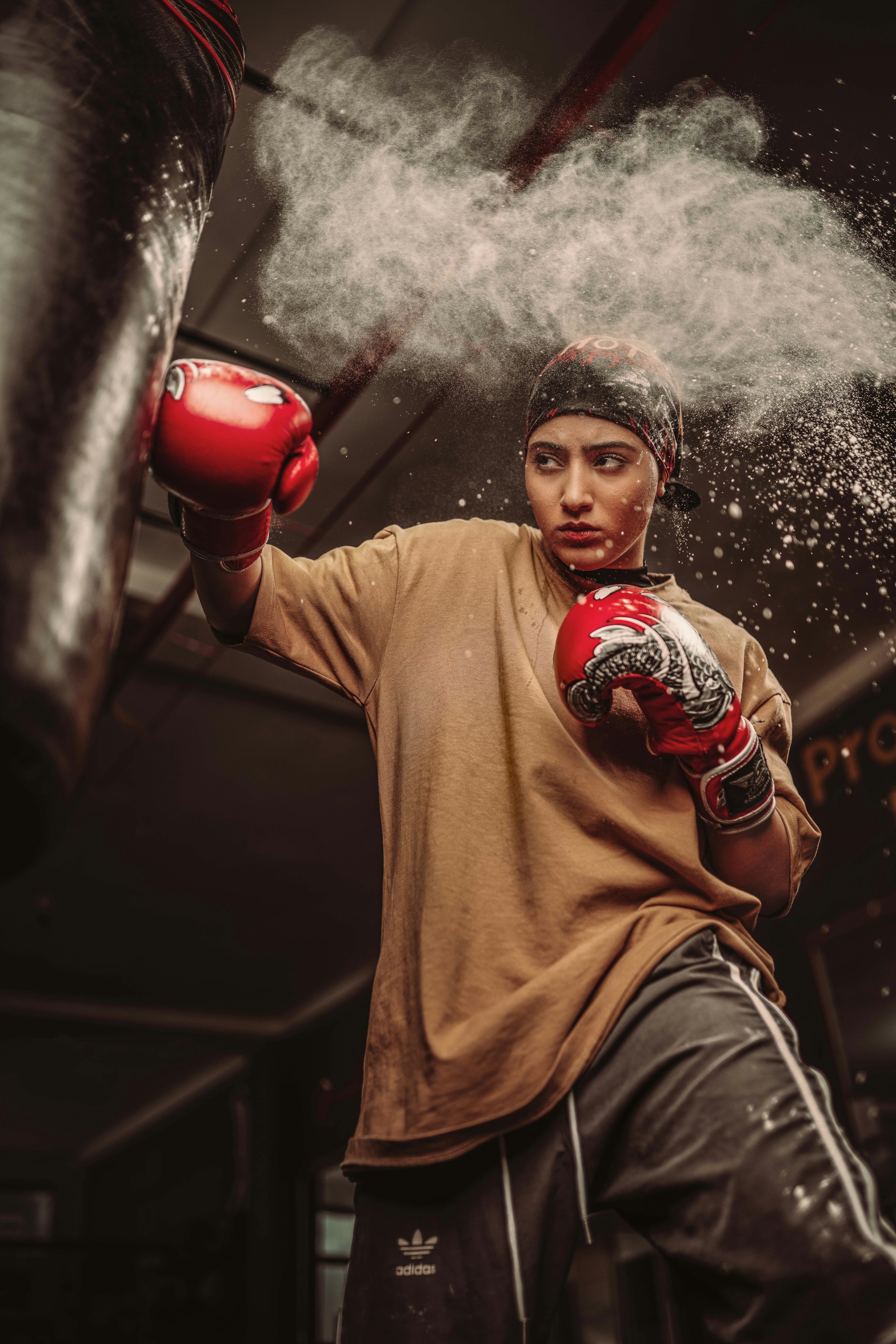 Female boxer mid-punch in training gym